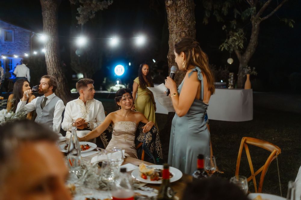 Outdoor wedding reception at night with string lights illuminating dining tables.