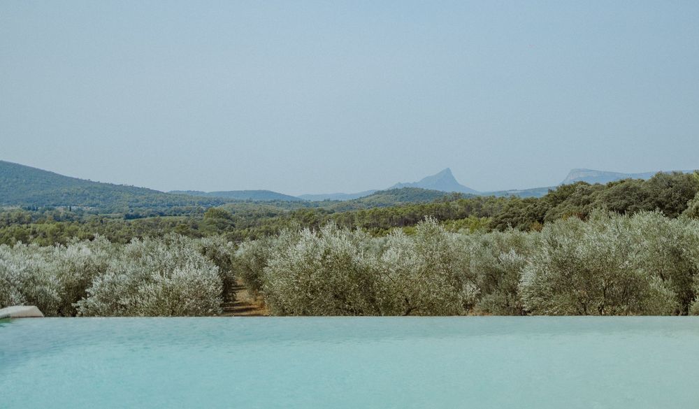 Panoramic view of a desert landscape with sagebrush and mountains in the distance under a clear blue sky.