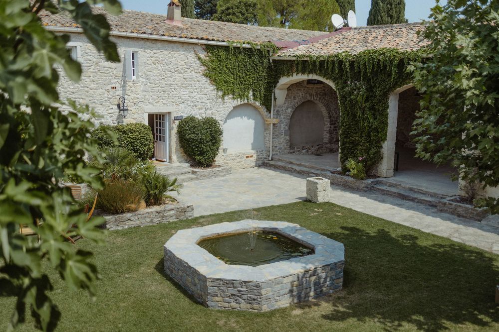 Stone garden features and pathways surrounded by lush greenery at a rustic venue.