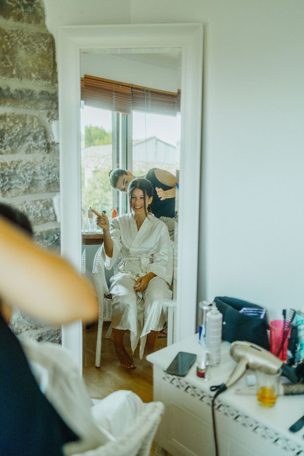 A sequence of blurry interior shots showing someone getting dressed in a bright white room with stone walls.