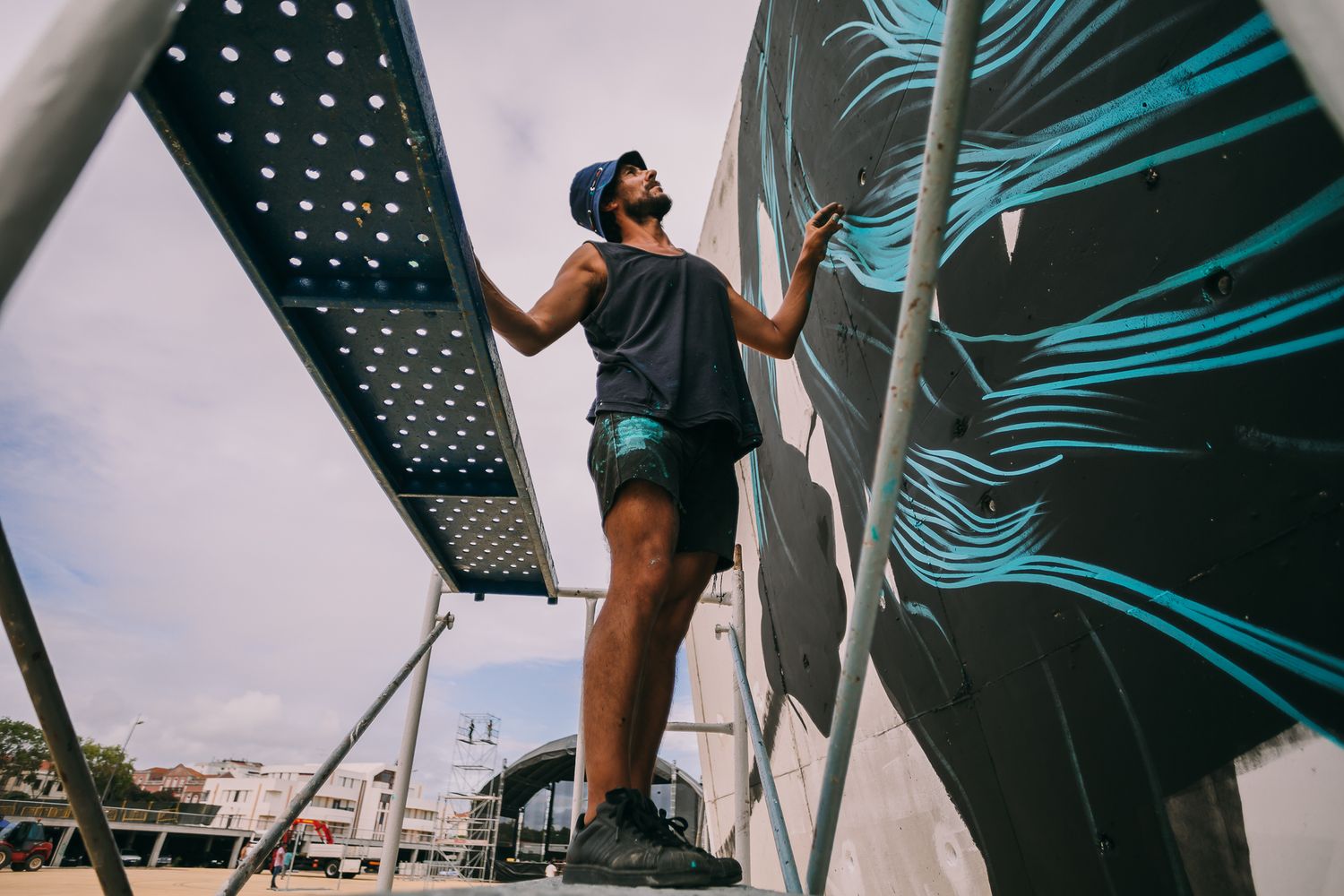 Modern urban architecture with turquoise palm leaf design creates dynamic geometric patterns.