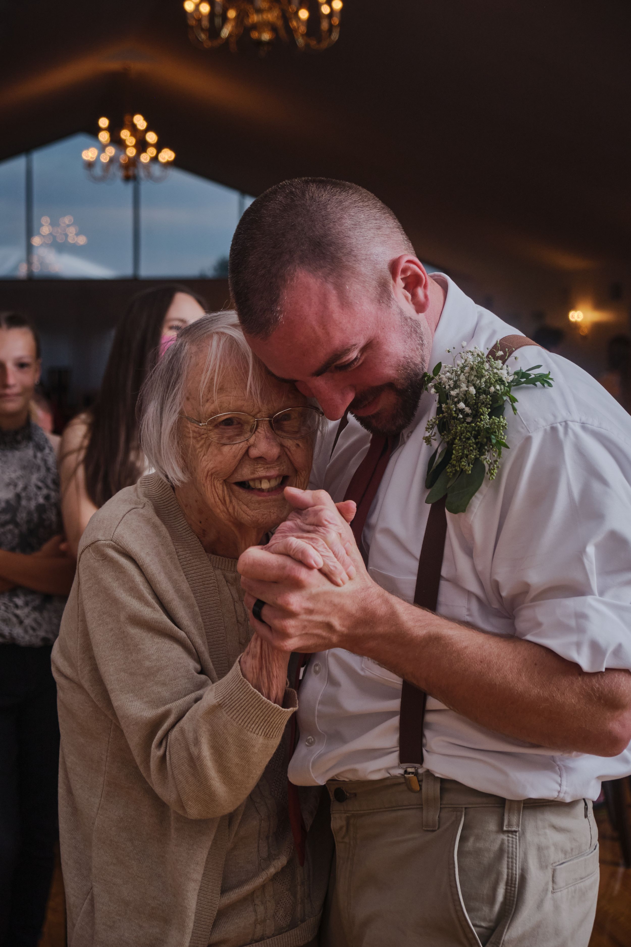Groom dances with grandma at Harmony Hall Estates. Triangle windows and Flowers.