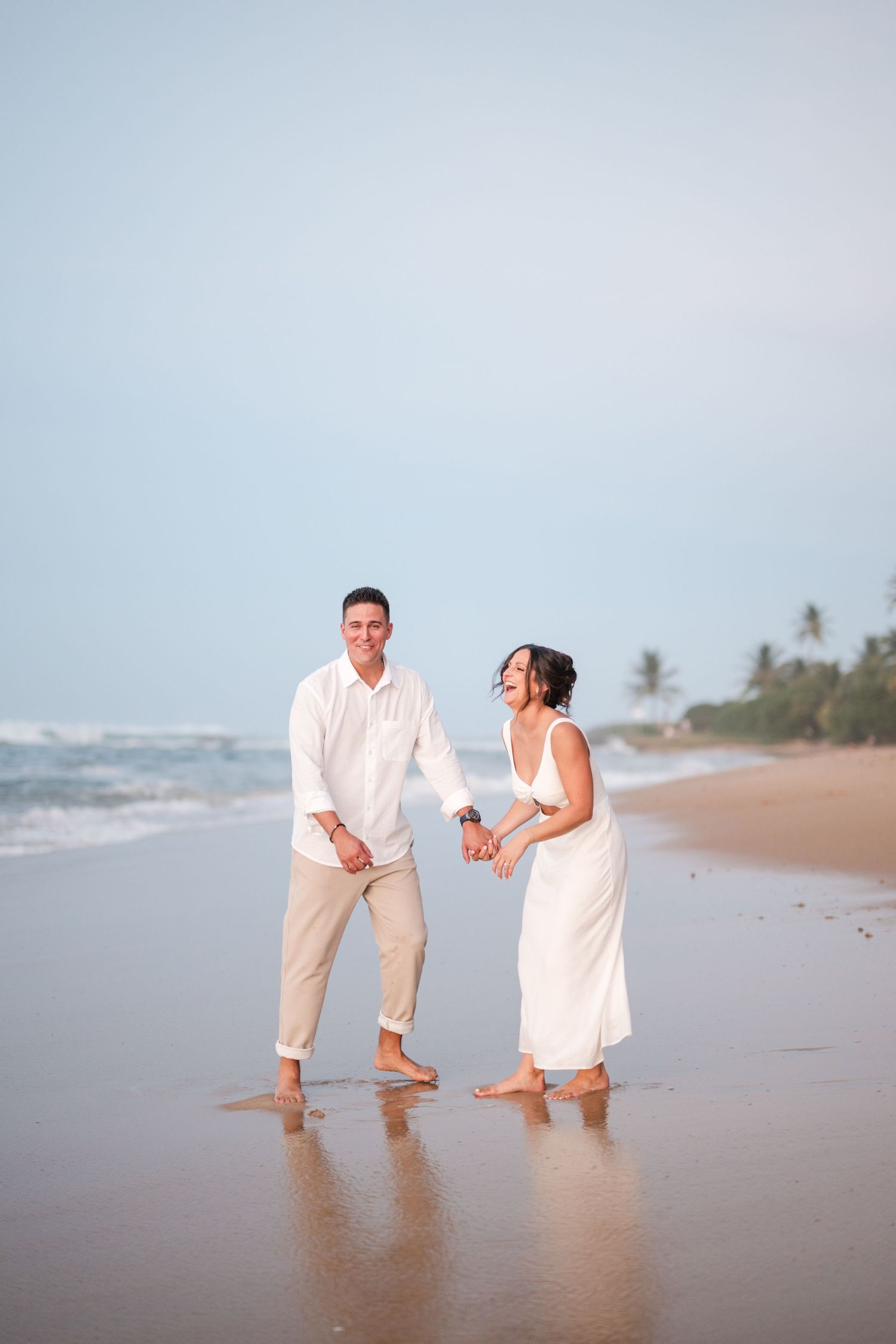 Couple walking barefoot along the shoreline at the beach in Puerto Rico during a relaxed engagement session