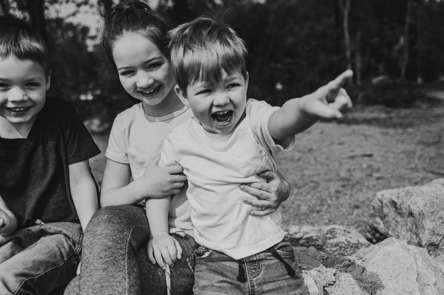 Children laughing, pointing, and playing together at Jack Darling Memorial Park, captured by a Mississauga lifestyle photographer