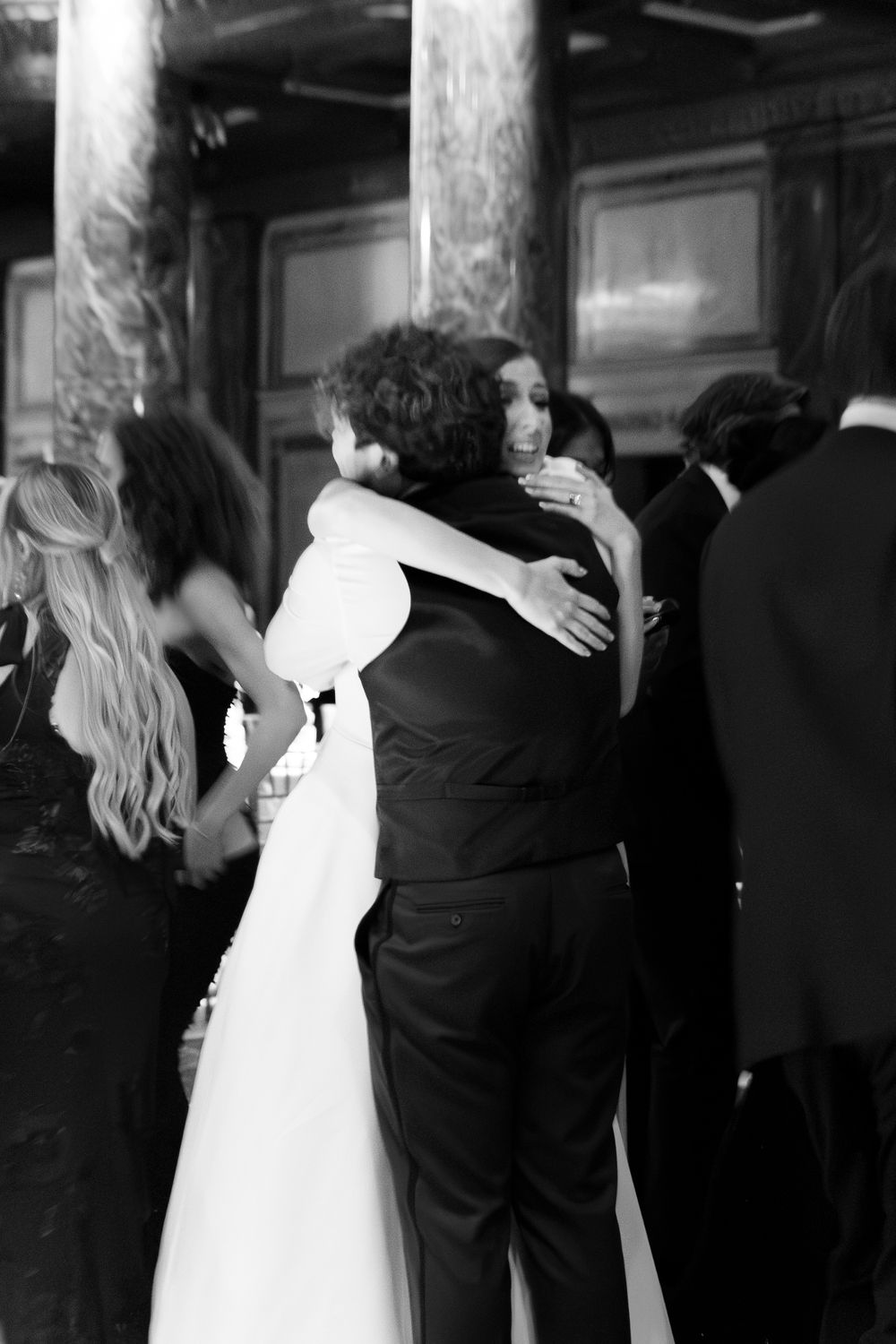 Black and white photo of bride and groom sharing a tender embrace at their wedding reception.
