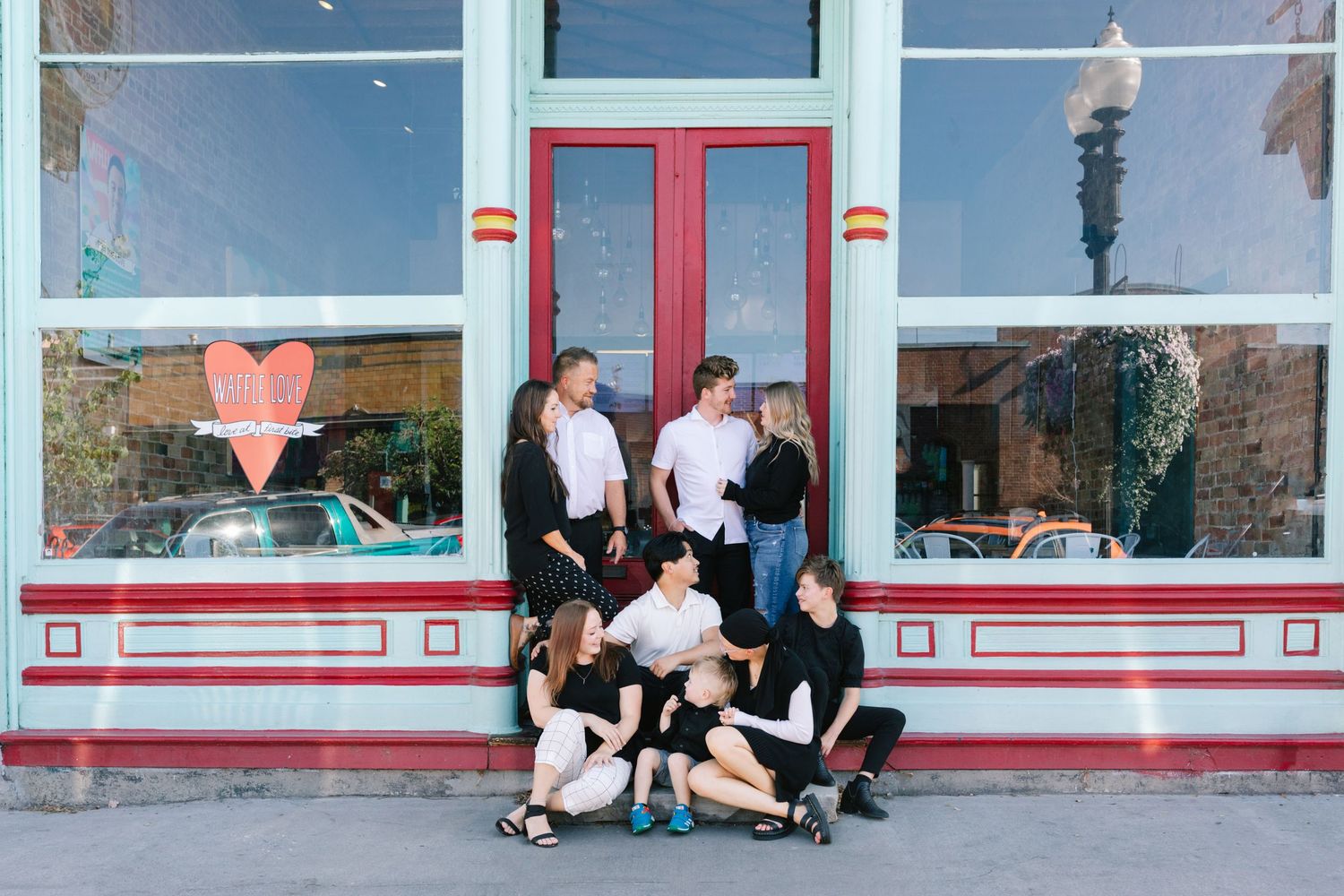 Large family pose playfully outside a vintage storefront at the Historic Ogden 25th street. Ogden family photographer