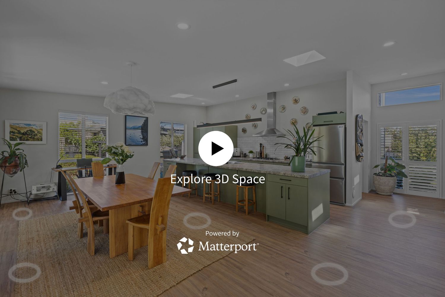 Matterport 3D virtual tour of a modern open-concept kitchen and dining room with wood table and green island.