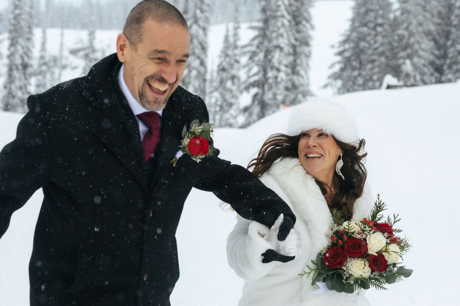 bride and groom laugh as they run through mountain trees in BC