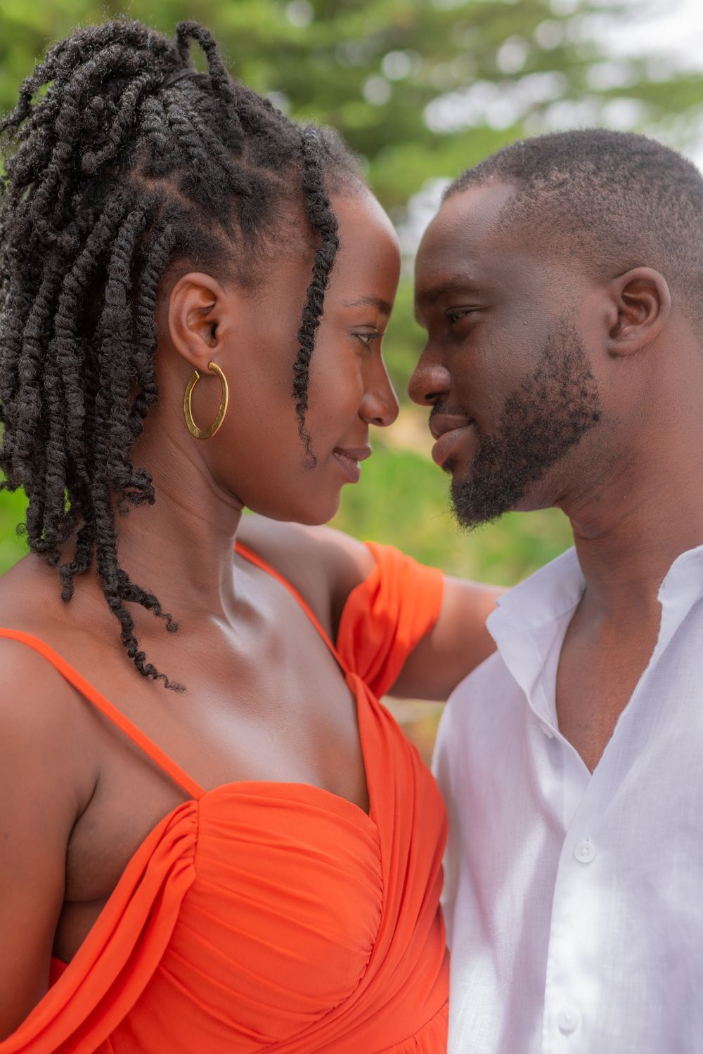 Close romantic portrait of an African couple facing each other outdoors in nature.