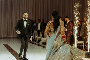 A sparkly celebratory moment at a wedding ceremony with pyrotechnics and a bride in a glittering gown on the runway.