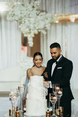 A stunning wedding reception features elegant white floral arrangements, candlelit tables and a romantic atmosphere.