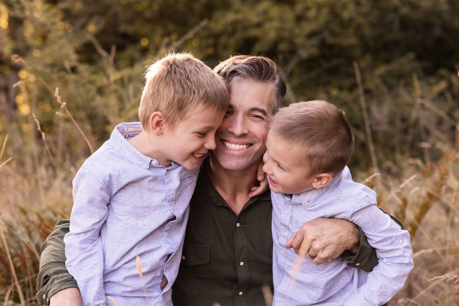 A heartwarming outdoor family portrait showing joyful expressions and embraces in a natural fall setting.