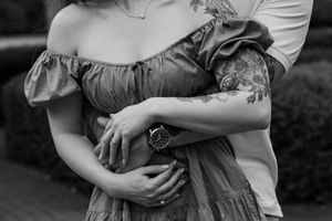 A romantic black and white engagement photo session showing intimate embraces between a couple in an outdoor setting.