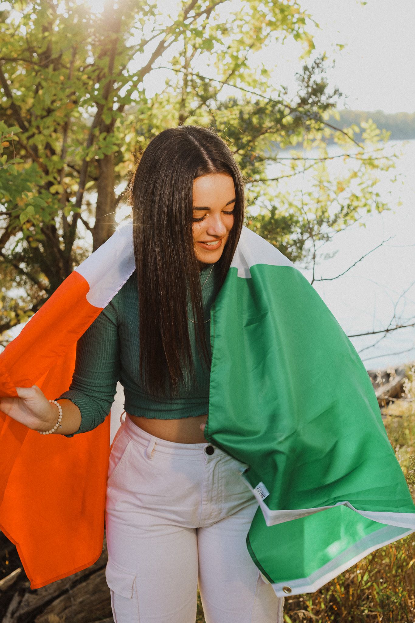 Colorful orange and green fabrics being held up against a sunny outdoor backdrop.