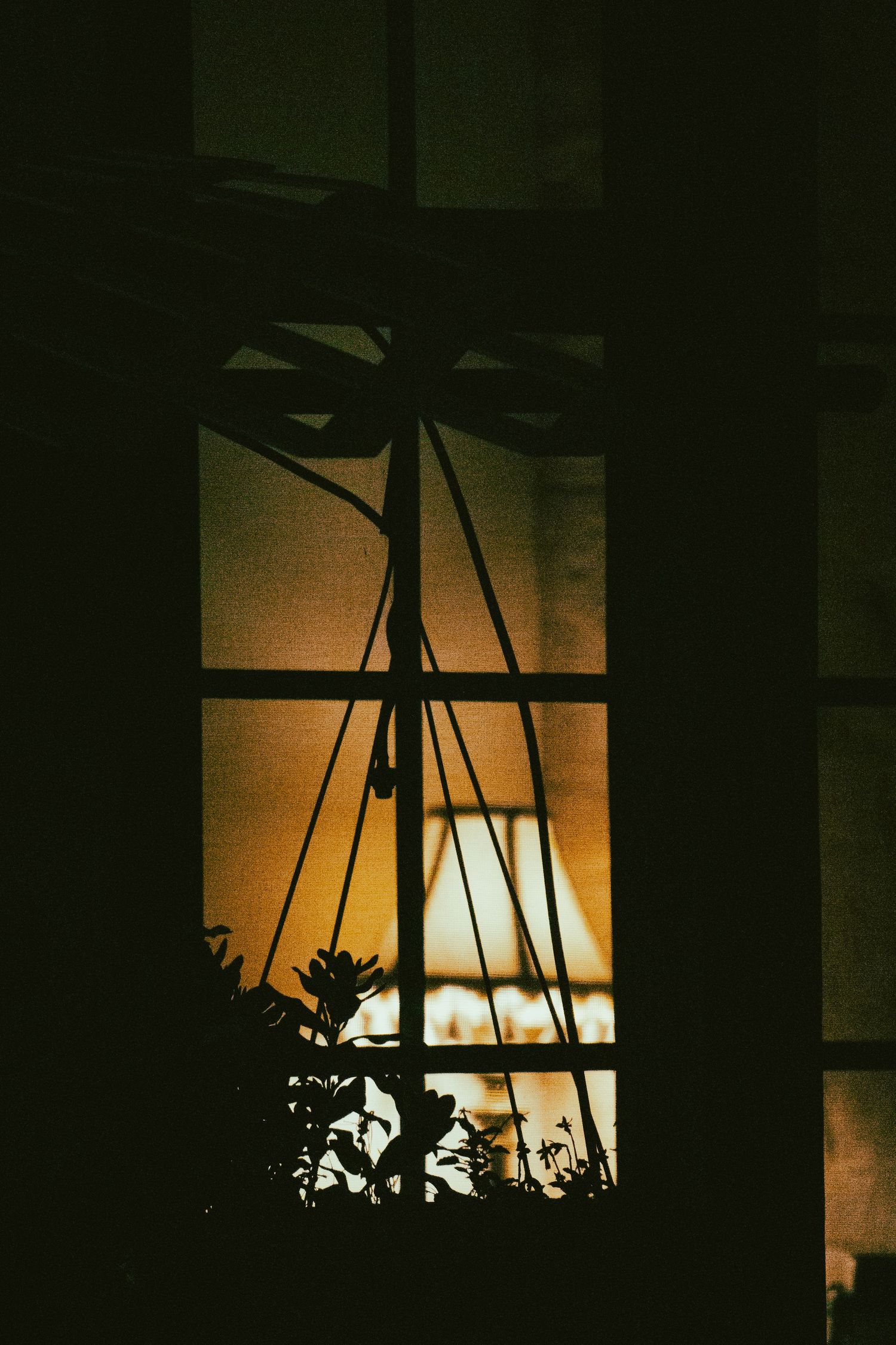 A silhouetted window framing a warm lamp