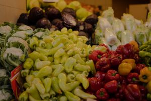 Fresh colorful bell peppers and produce on display at a local farmers market or grocery store.
