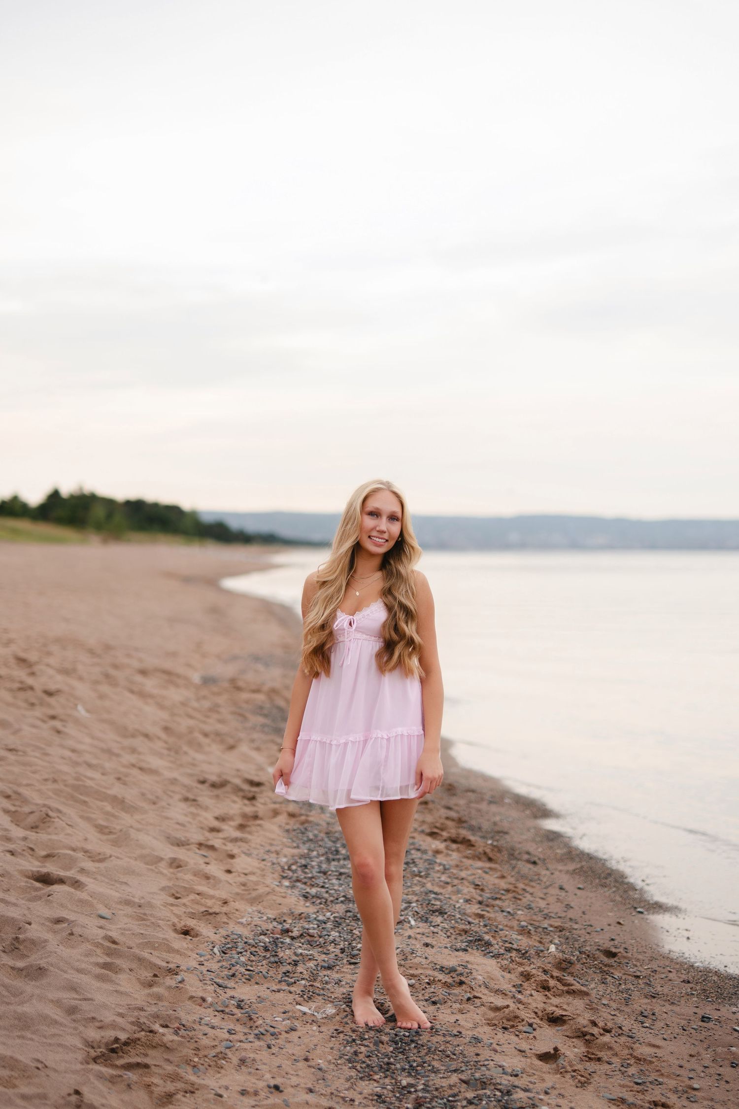 A series of photos showing a person in a pink dress walking and posing on a sandy beach at sunset.