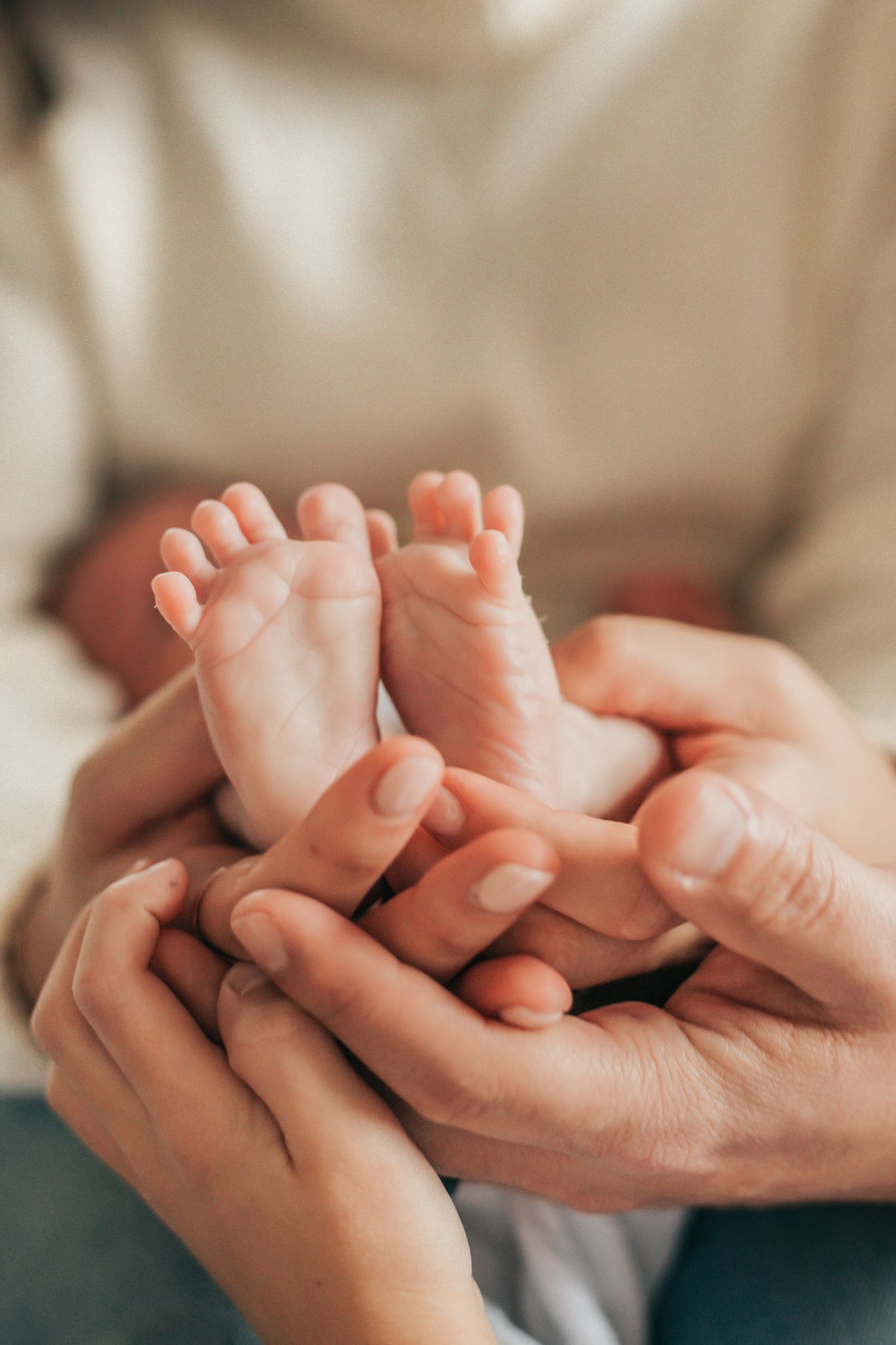 family holding newborn babies feet