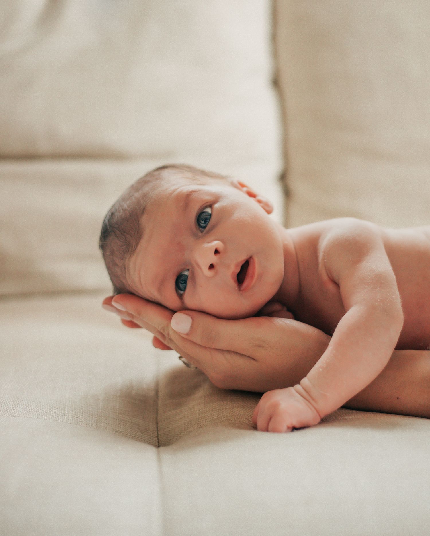 newborn baby laying on mother's hand