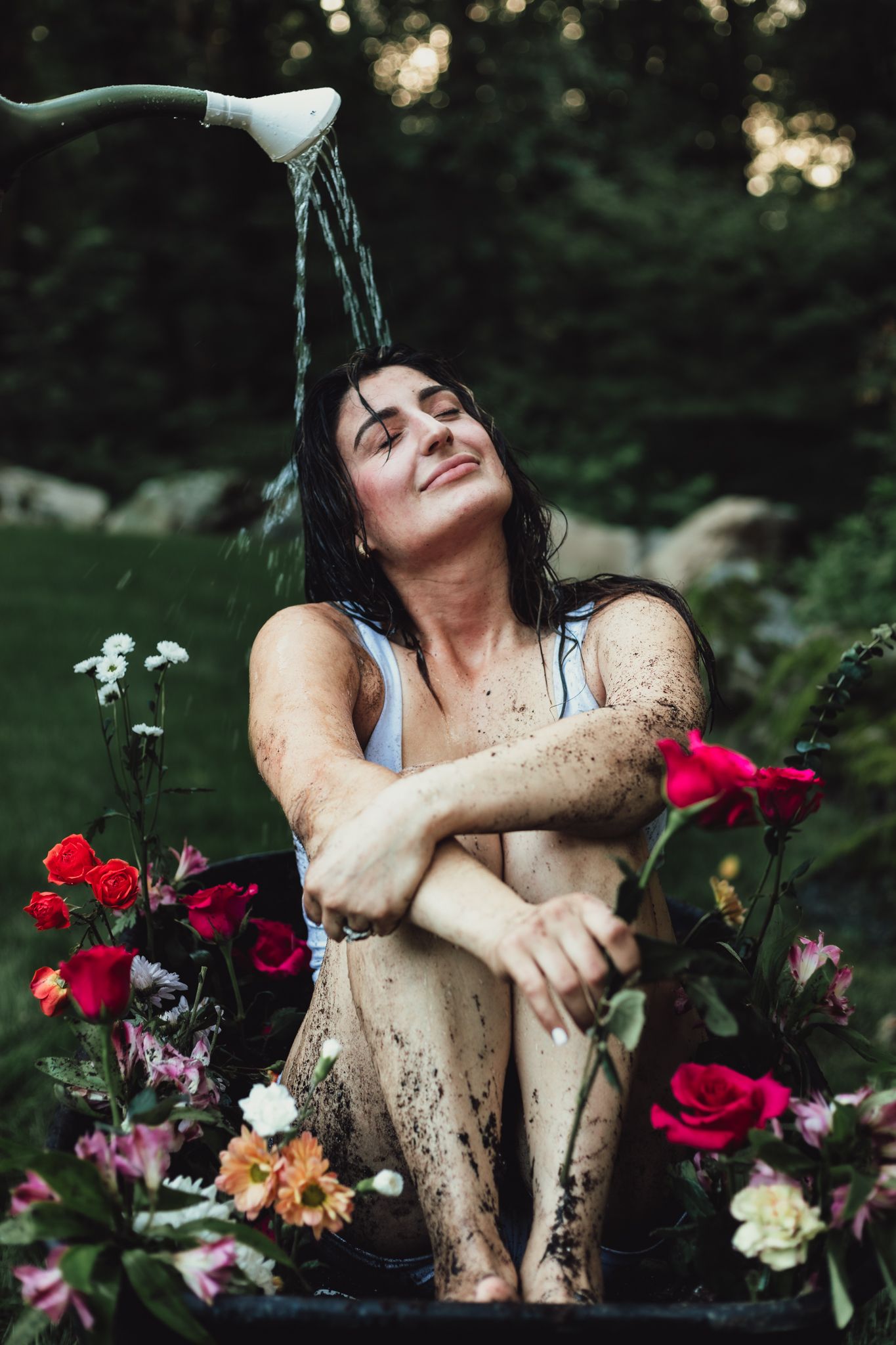 woman in wheelbarrow holding flower, emotional, raining, garden, dramatic, lifestyle, creative photoshoot, themed