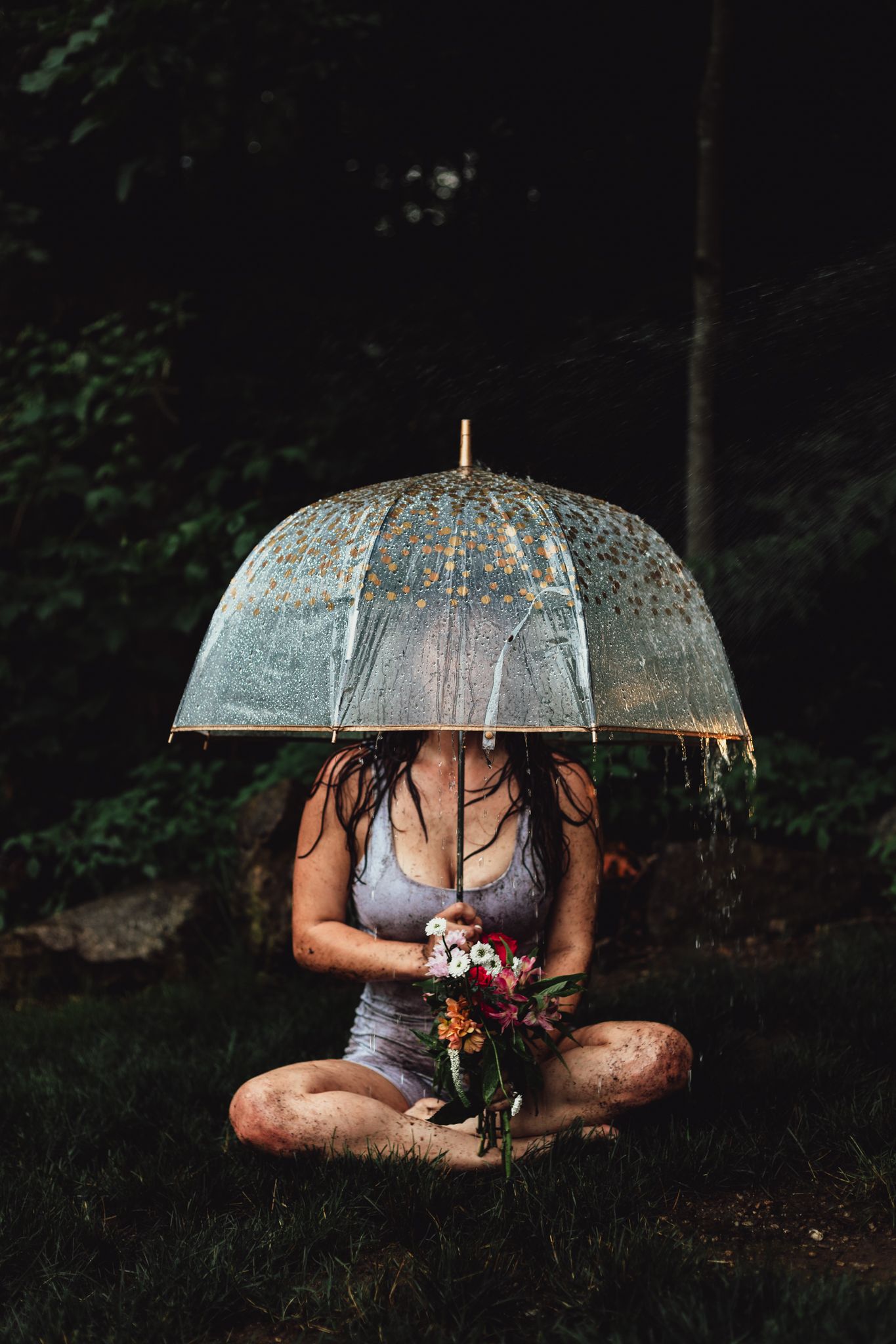 woman in wheelbarrow holding flower, emotional, raining, garden, dramatic, lifestyle, creative photoshoot, themed