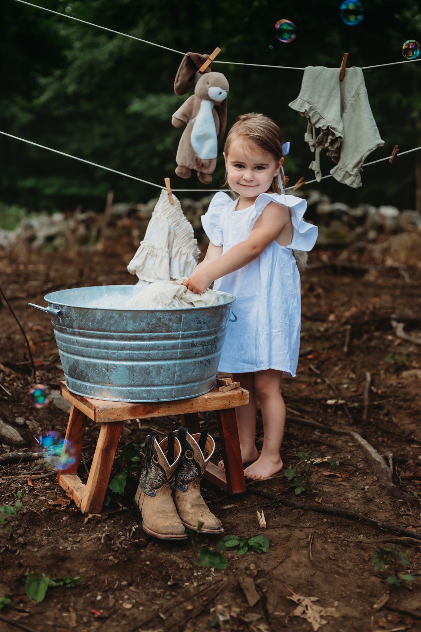 themed session. little girl washing laundry by hand, cowboy boots, bunny rabbit
