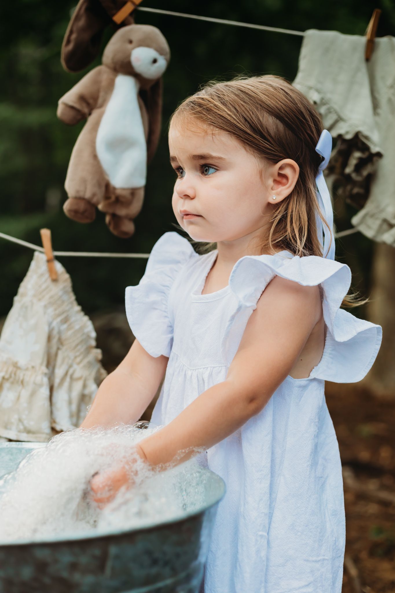themed session. little girl washing laundry by hand, cowboy boots, bunny rabbit