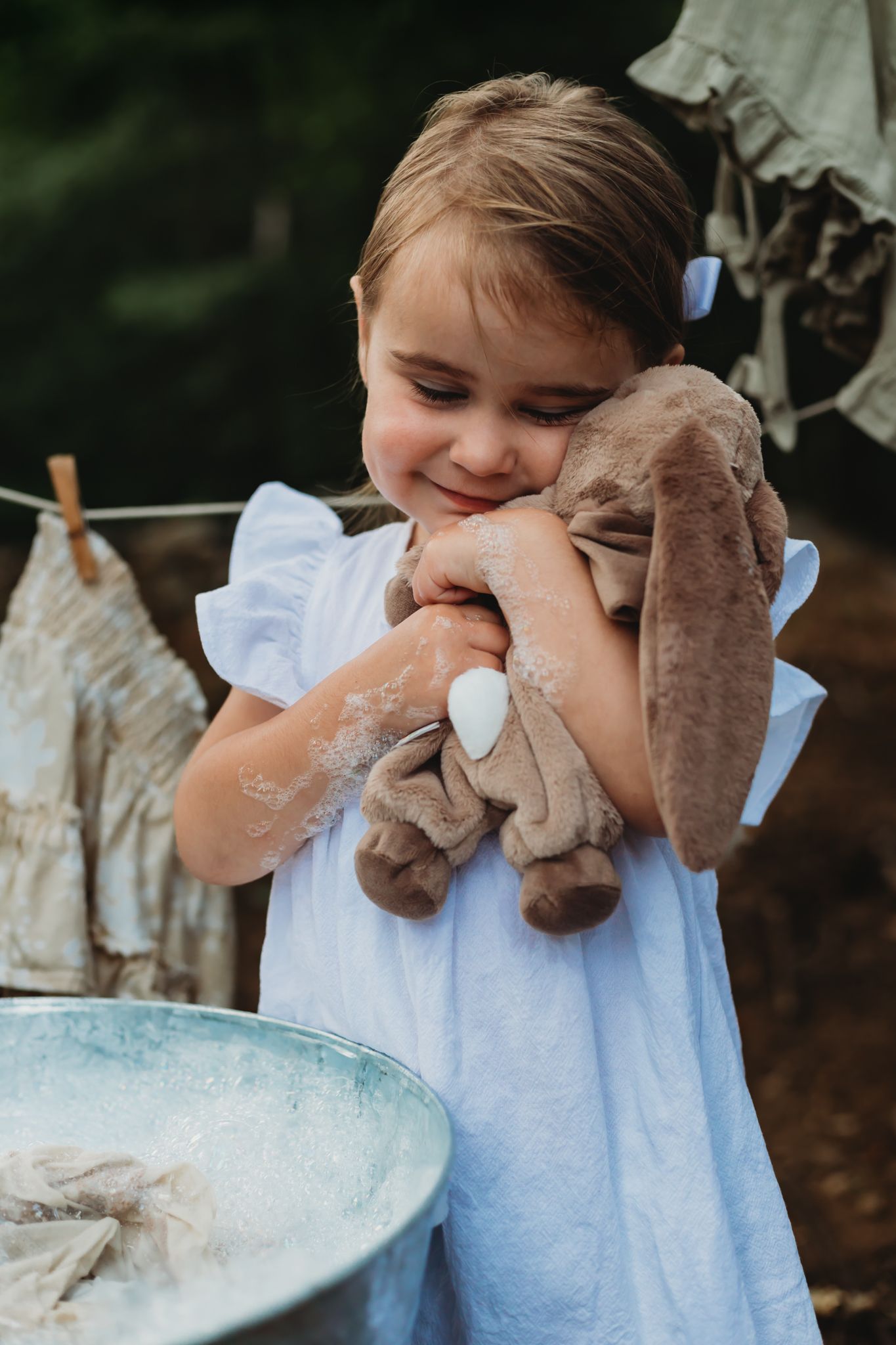 themed session. little girl washing laundry by hand, cowboy boots, bunny rabbit