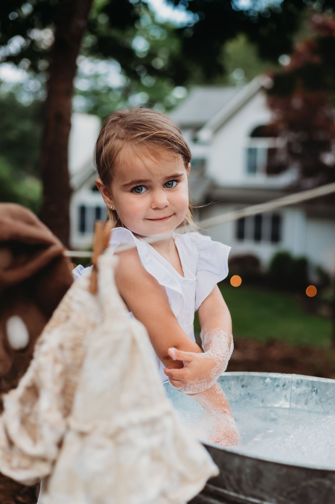 themed session. little girl washing laundry by hand, cowboy boots