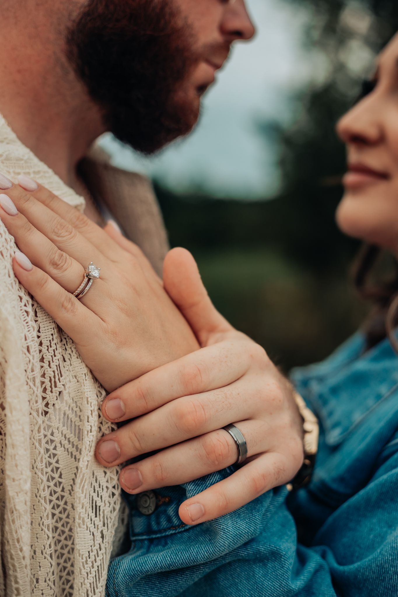 bride's hand on grooms shoulder showing both of their wedding rings