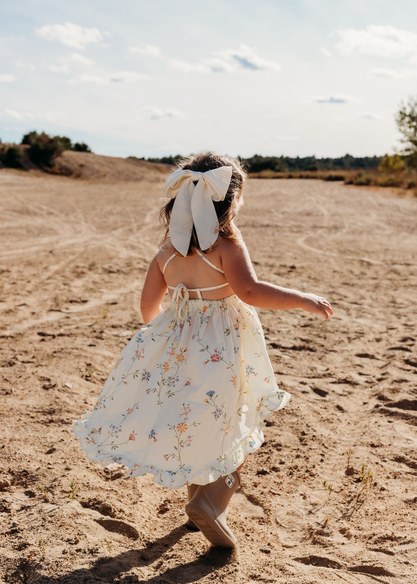girl running through the sand dunes at sunset