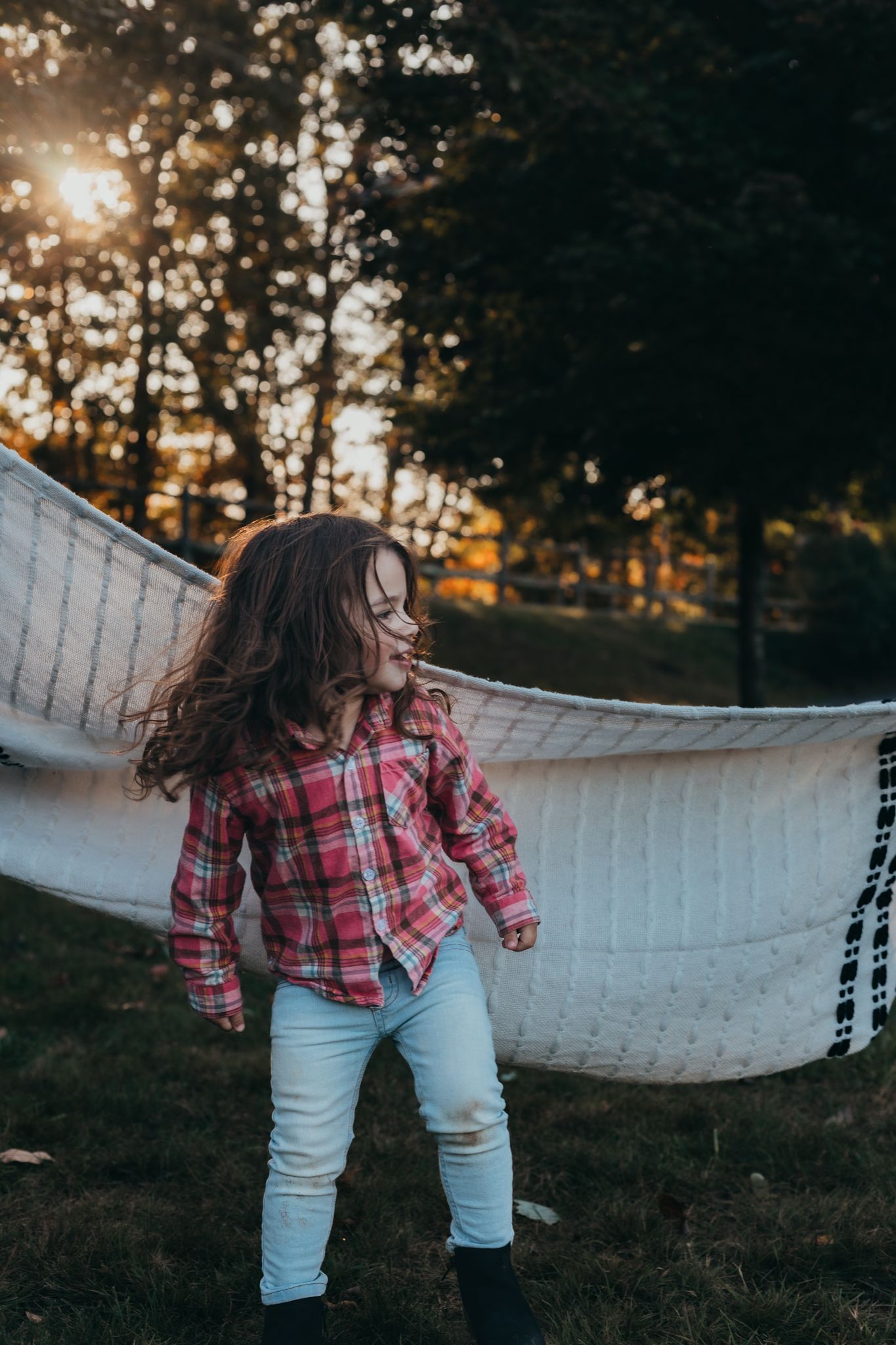 girl playing under the sunset with her family