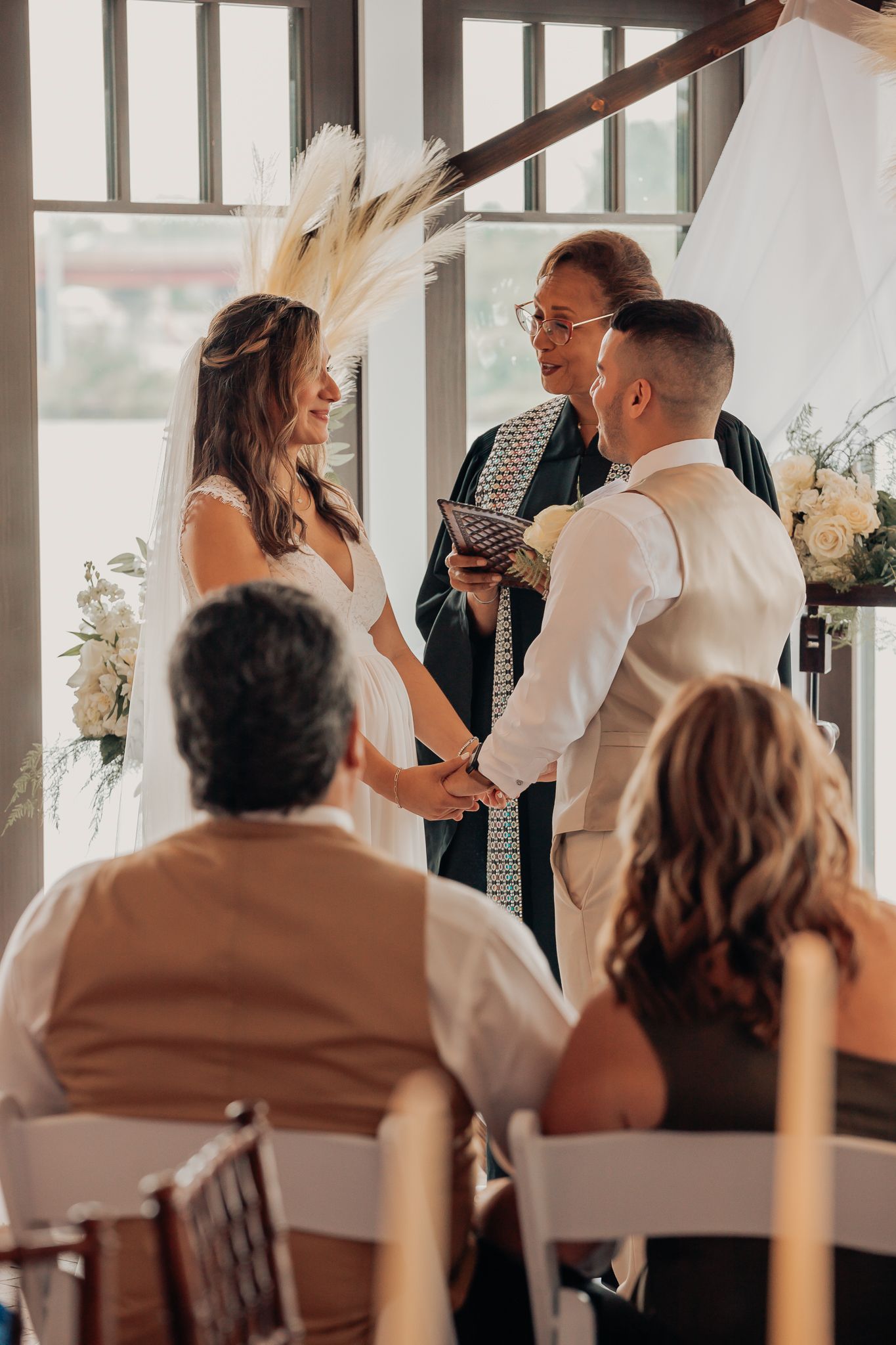 parents of the bride watching the bride and groom say their vows at their wedding