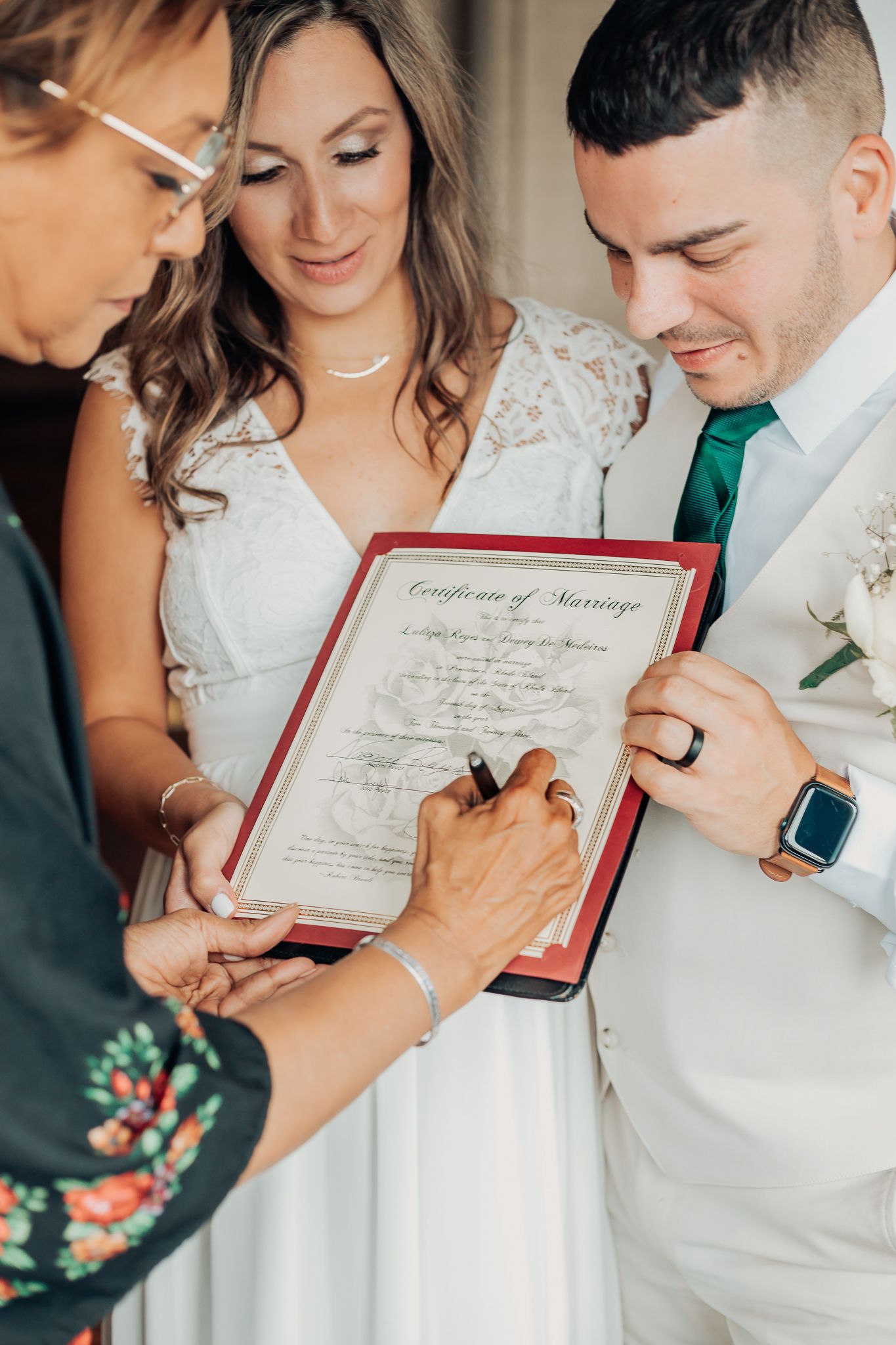 bride and groom watching officiant sign marriage certificate