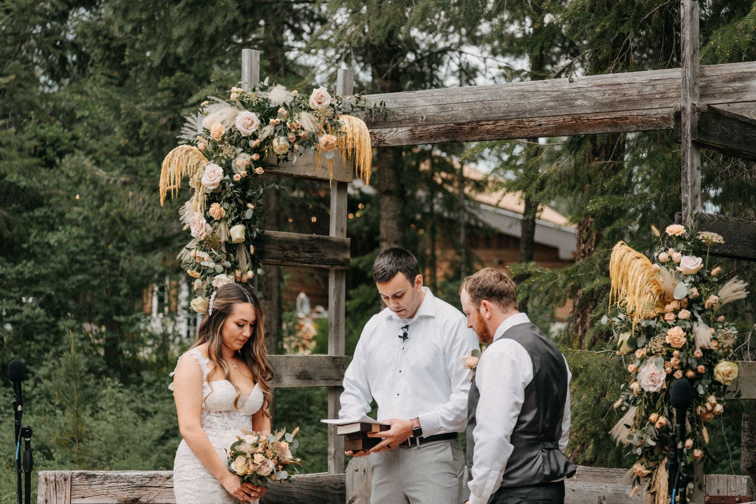 Romantic outdoor wedding ceremony under rustic wooden arch decorated captured by wedding videographer Jovan Films.