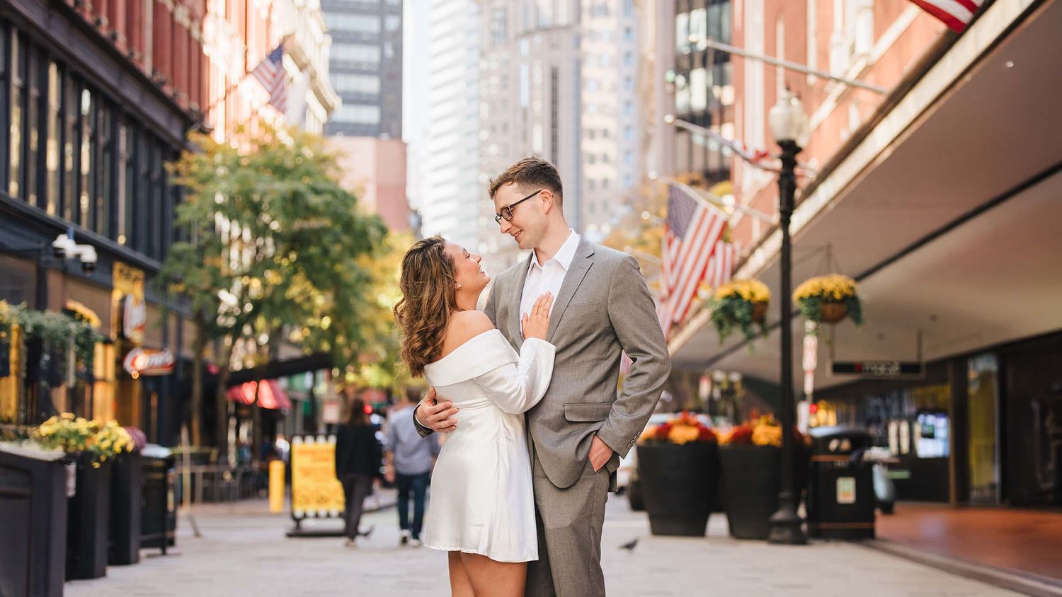 A romantic moment during their Boston Engagement Session the bride and groom to be embrace on Summer street in downtown Crossing area.