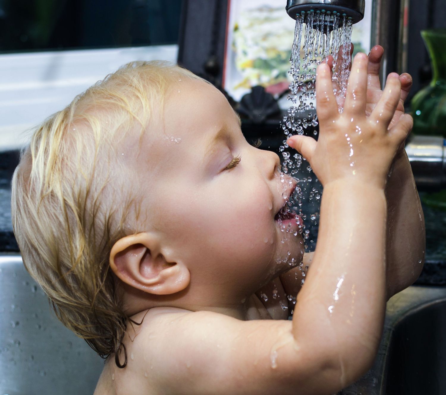 Candid portrait - Baby playing with water while bathing in sink. #eventphotography #eventphotographer #photographer #portraitphotographer
