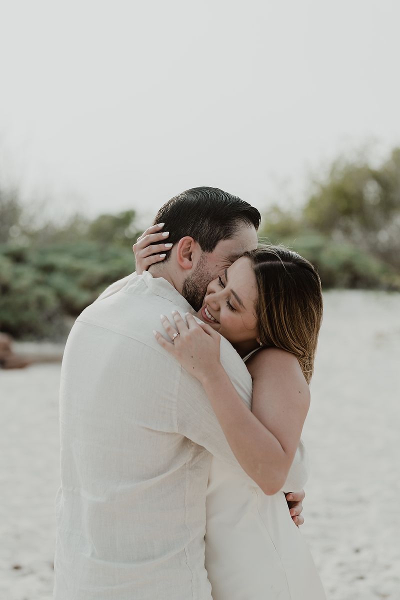 Elegant engagement portrait of a couple hugging on the beach at Paradisus Resort.