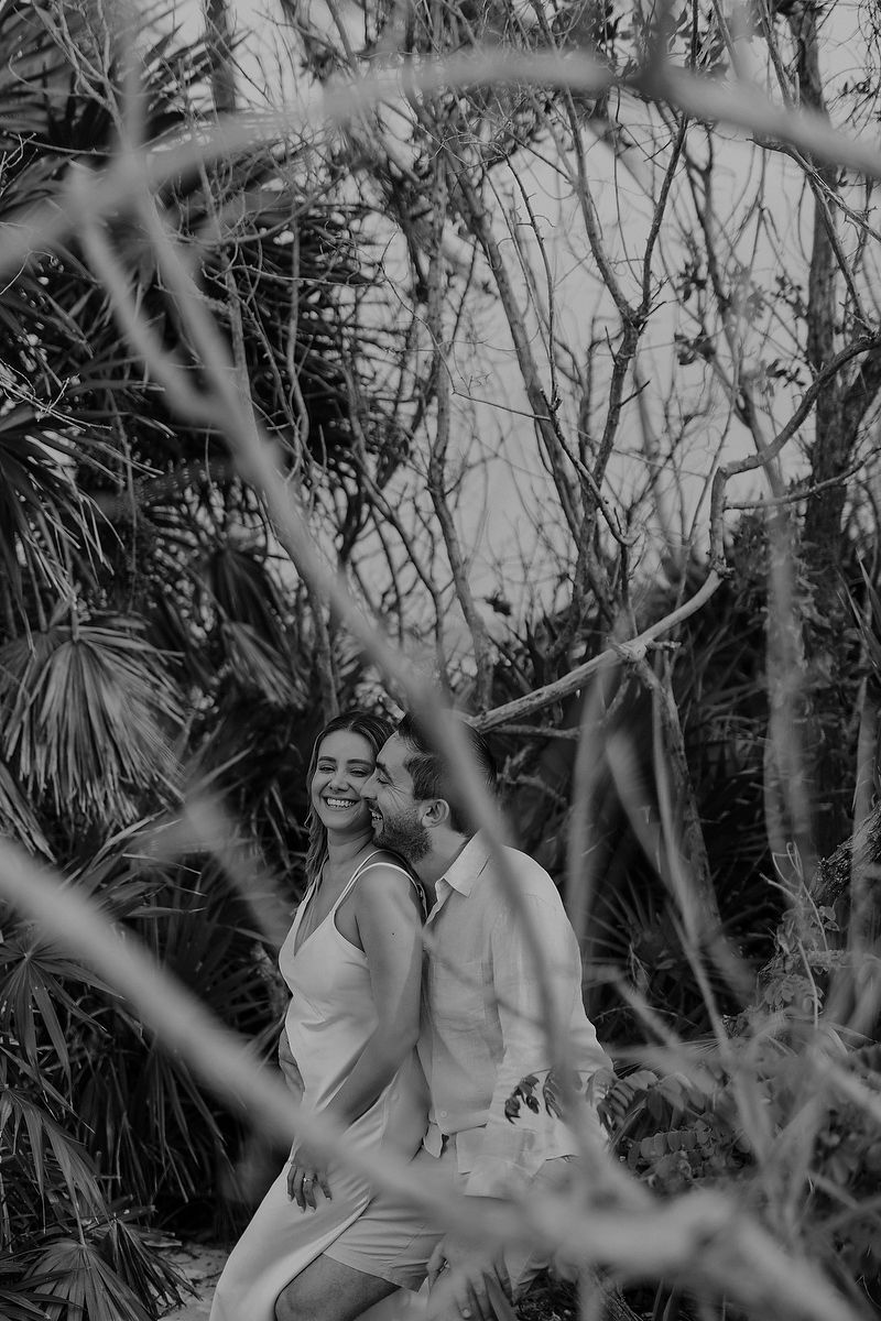 Black and white editorial engagement portrait surrounded by tropical jungle in Playa del Carmen.