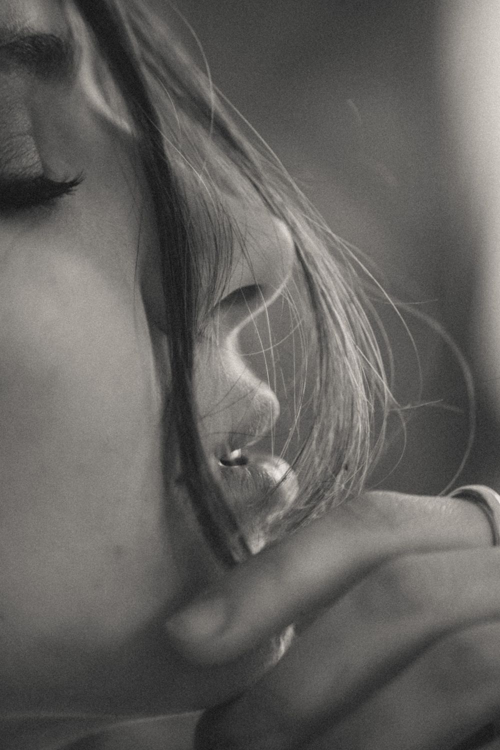 Close-up black and white photo of an ear and flowing hair with soft lighting.