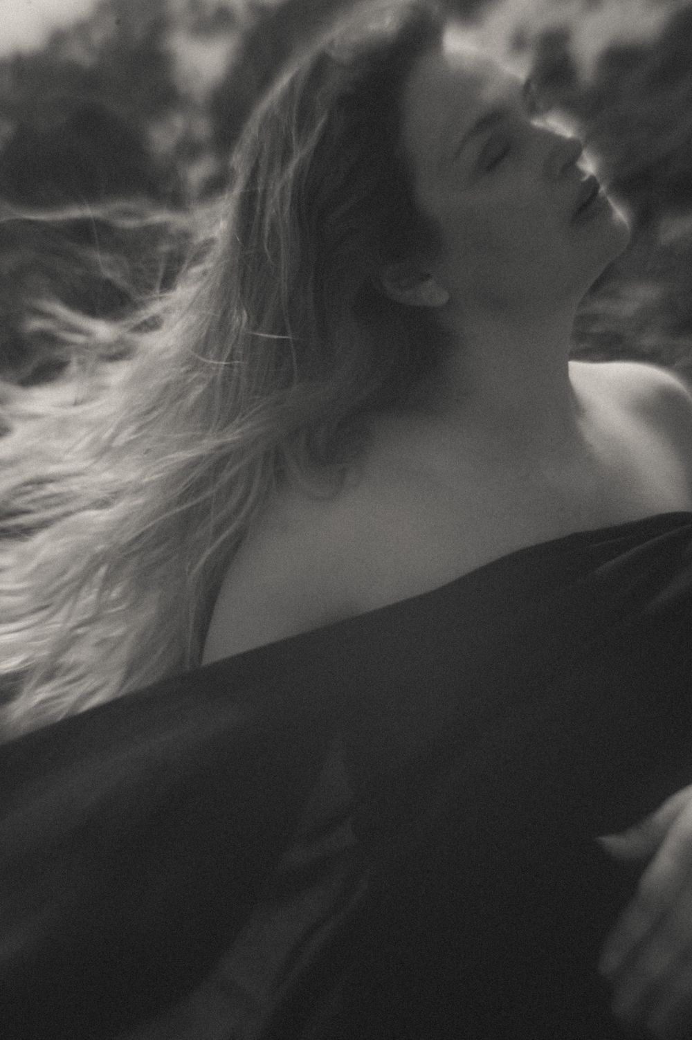 Ethereal black and white close-up profile view with flowing hair.