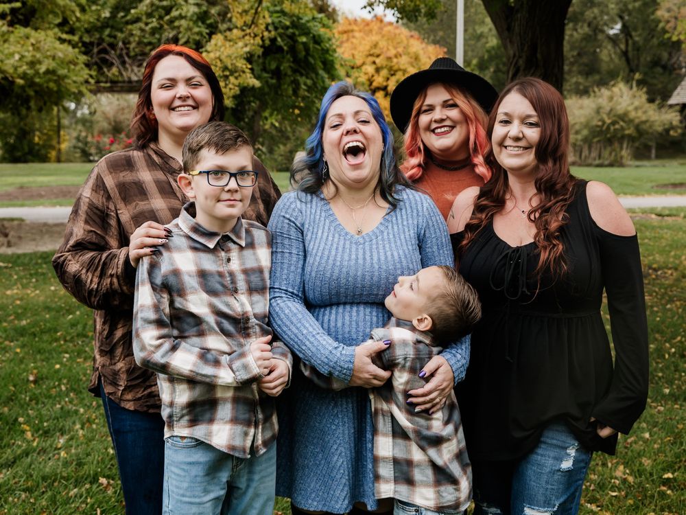 Candid group photo showing joyful laughter and casual interactions outdoors.