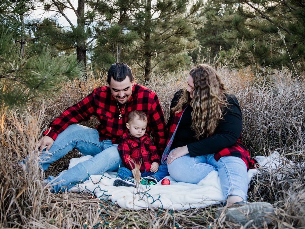 Winter family photoshoot sequence with red plaid shirts on blanket among pine trees.