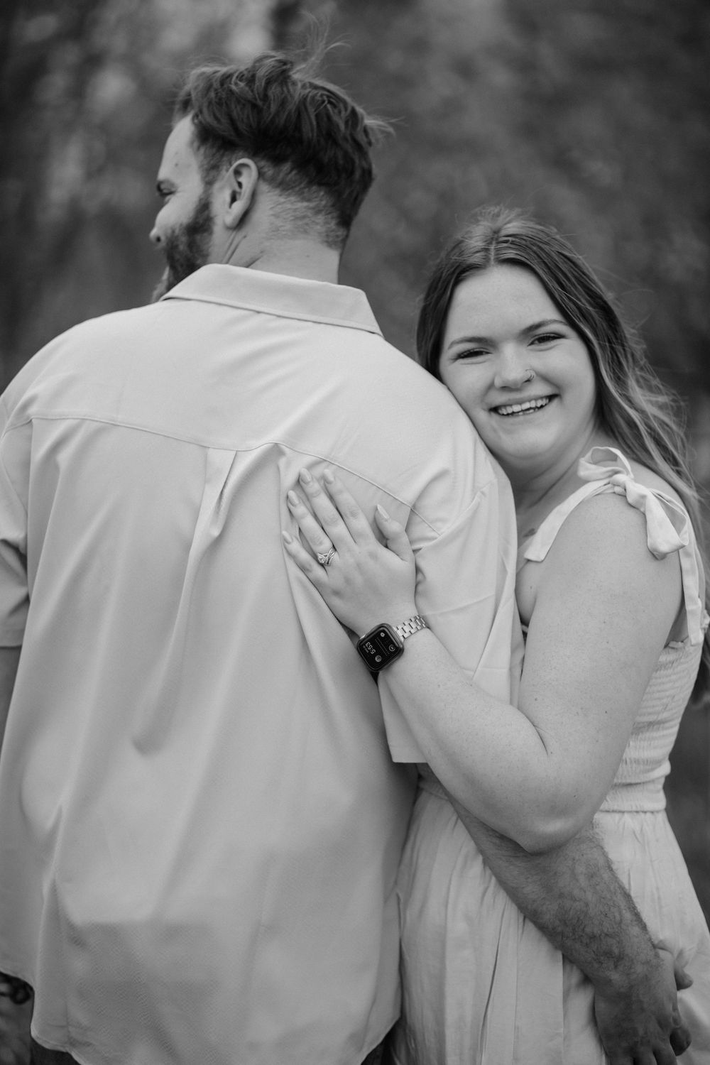 Black and white intimate portrait of couple embracing outdoors.