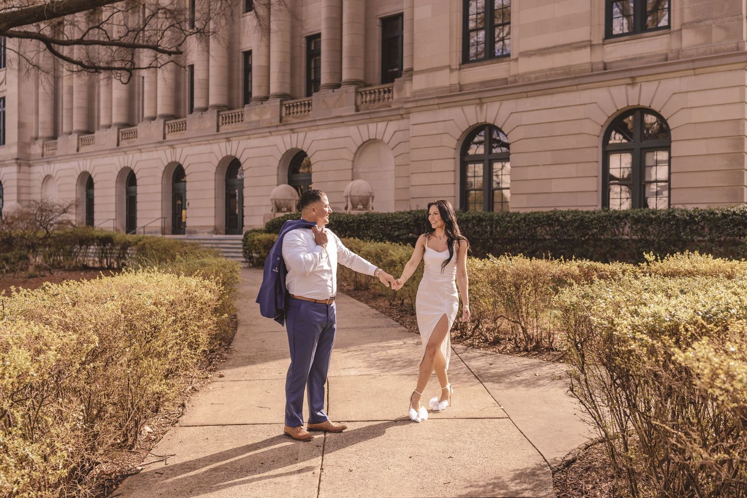 Engaged couple dancing on the sidewalk outside the courthouse in Charlotte, NC. Charlotte, nc wedding and engagement photographer