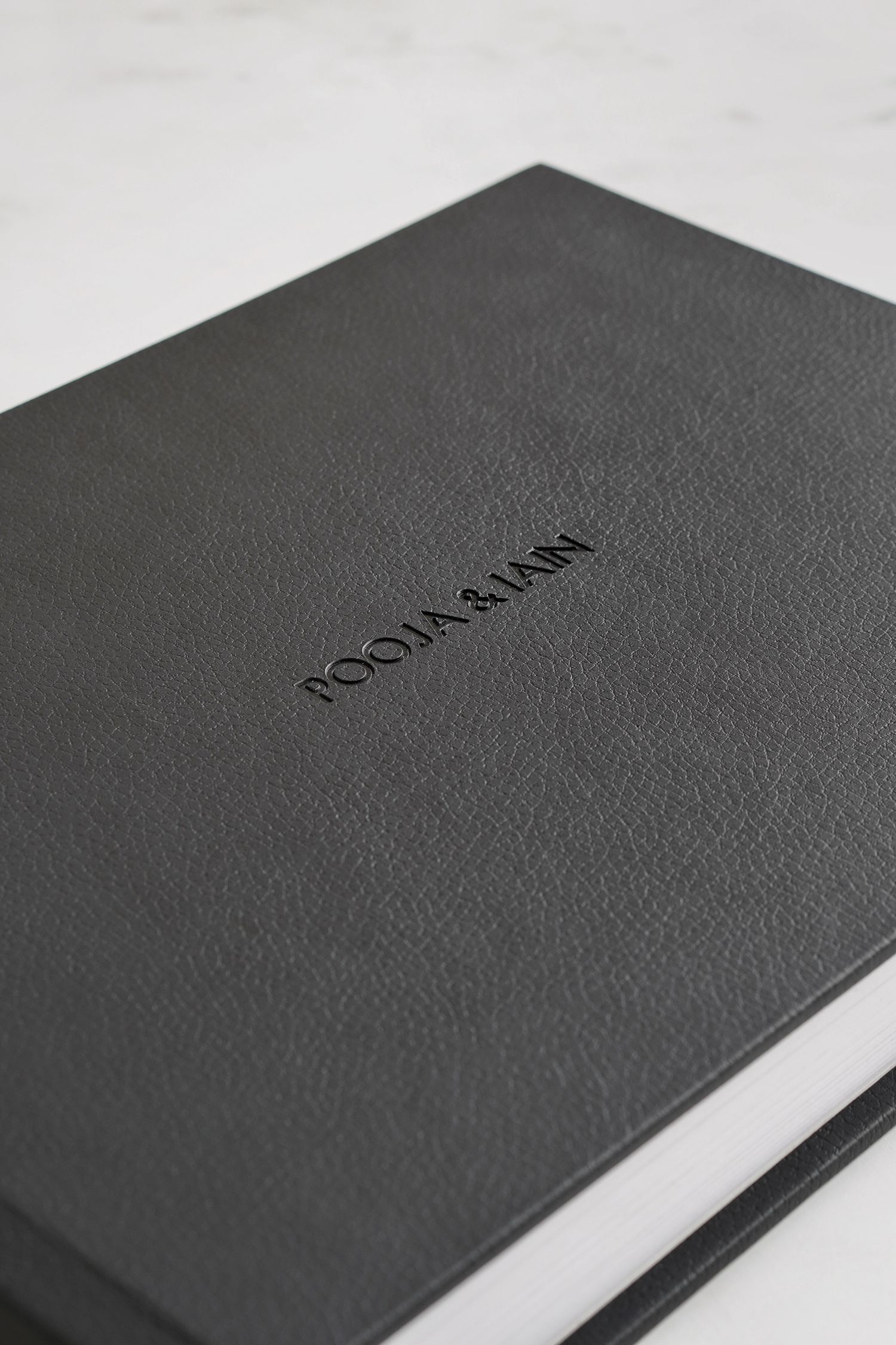 Black textured leather notebook or journal cover shown at various angles in a minimalist product photography style.