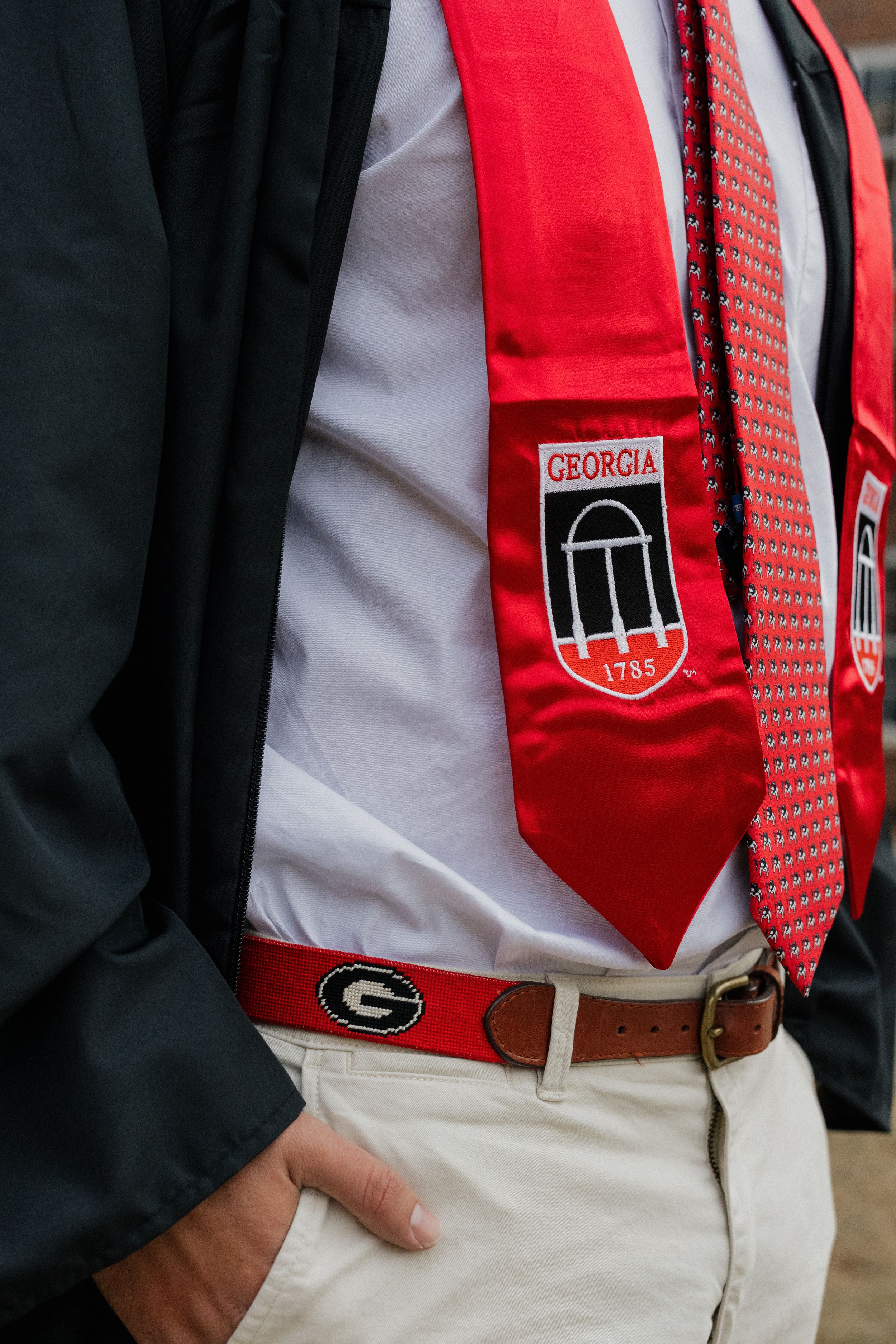 Close-up details of UGA graduation stole and tie with arch logo.