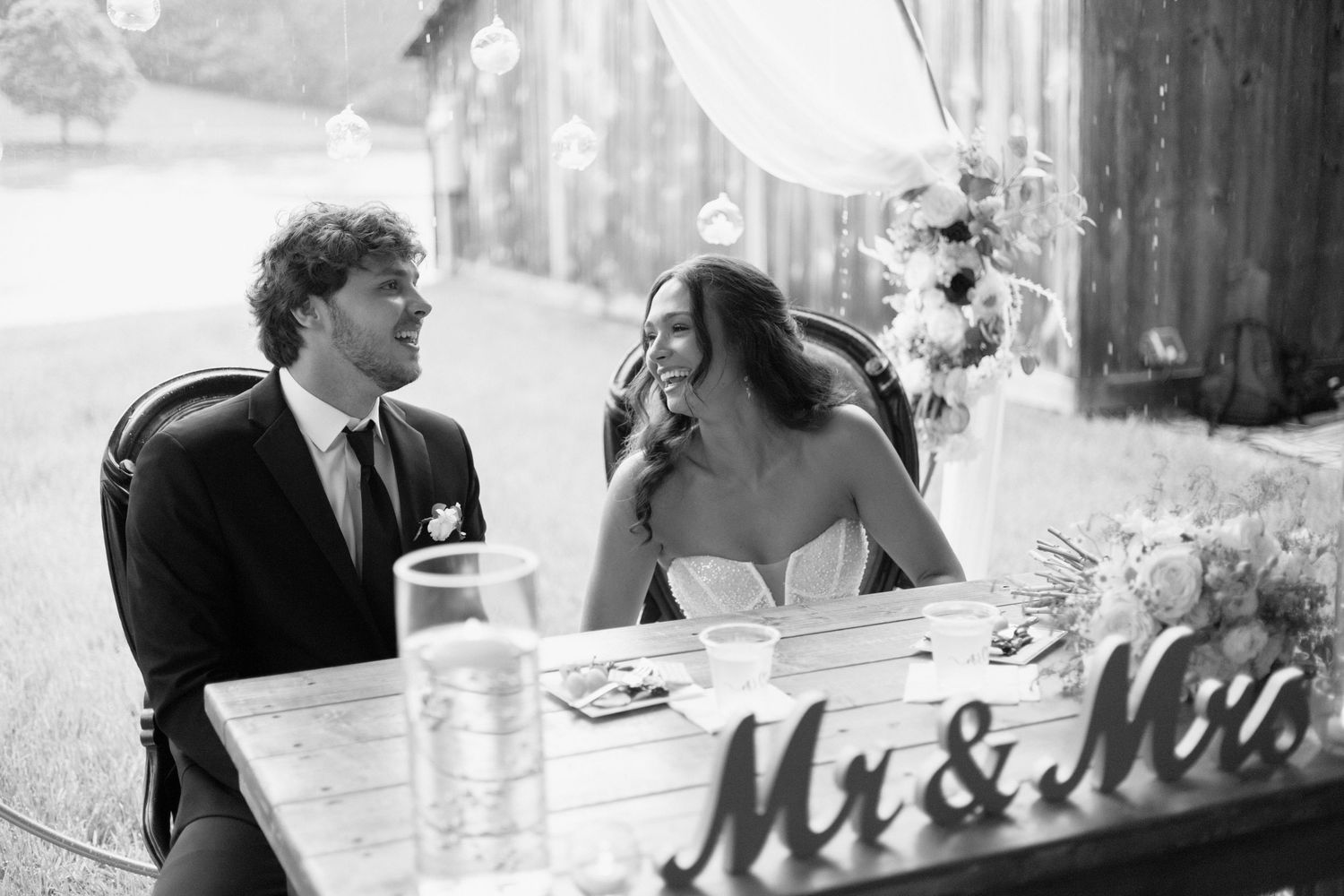 A series of black and white wedding photos showing intimate moments between couples during their celebration.