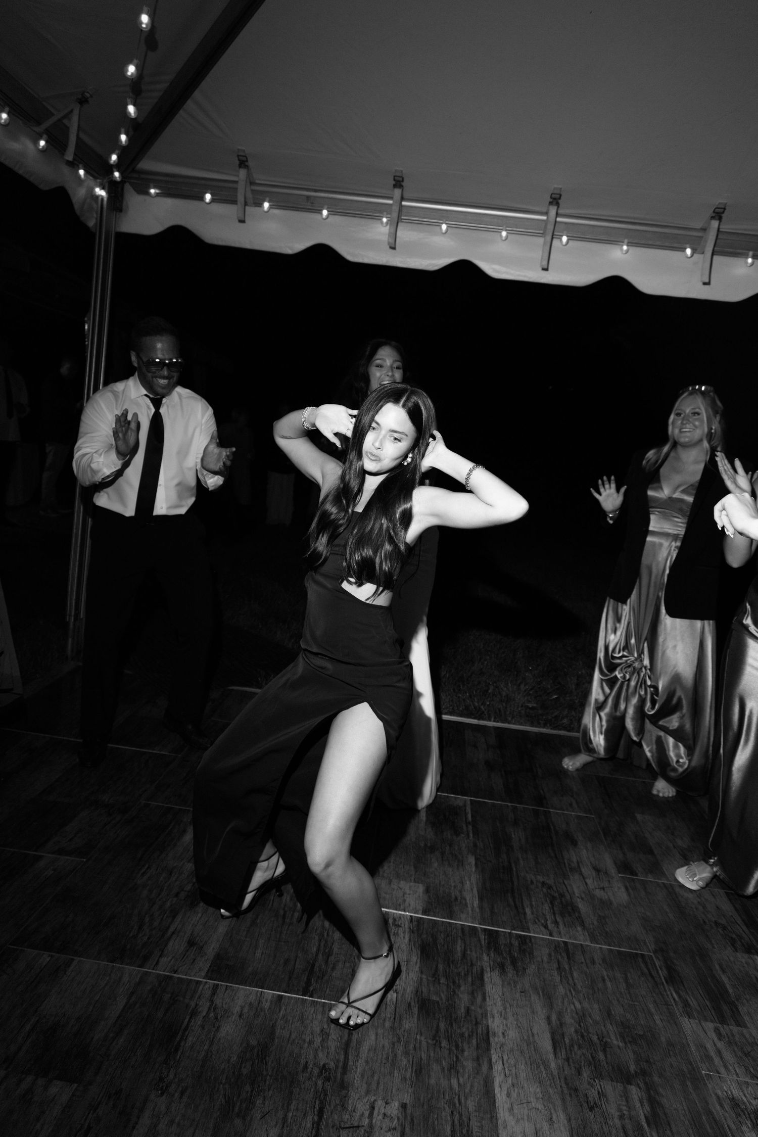 A series of black and white photos showing dancers performing on a wooden dance floor in a dimly lit room.