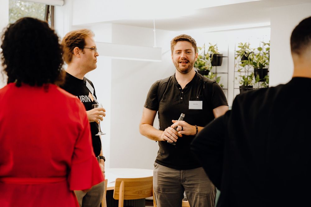 People wearing name tags networking and mingling during a casual business event.